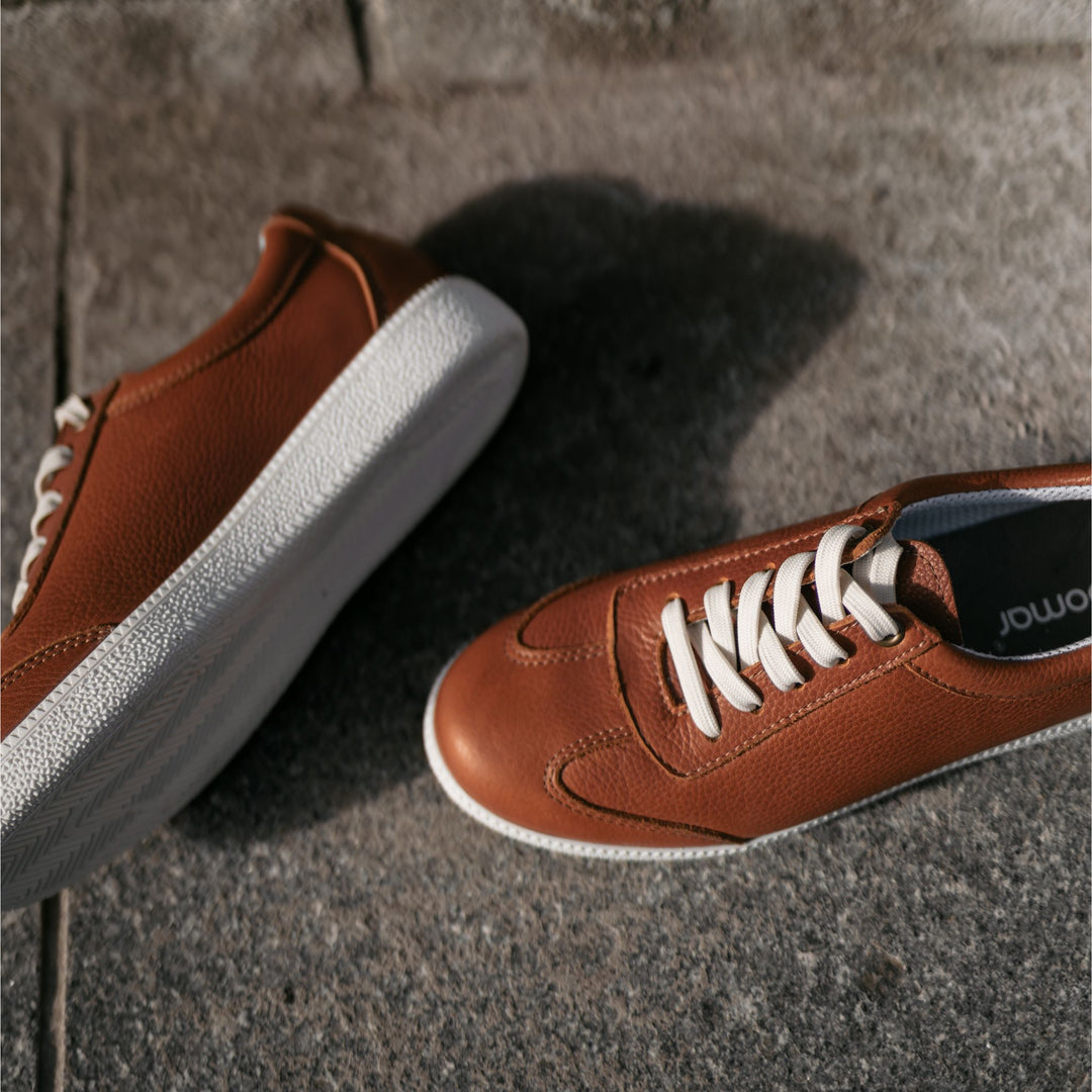 Naisten tennarit maassa.