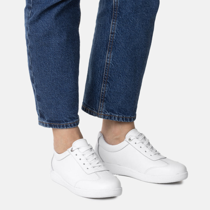 Fiiliskuva KARLA naisten valkoisista tennareista mallin päällä valkoisella taustalla.