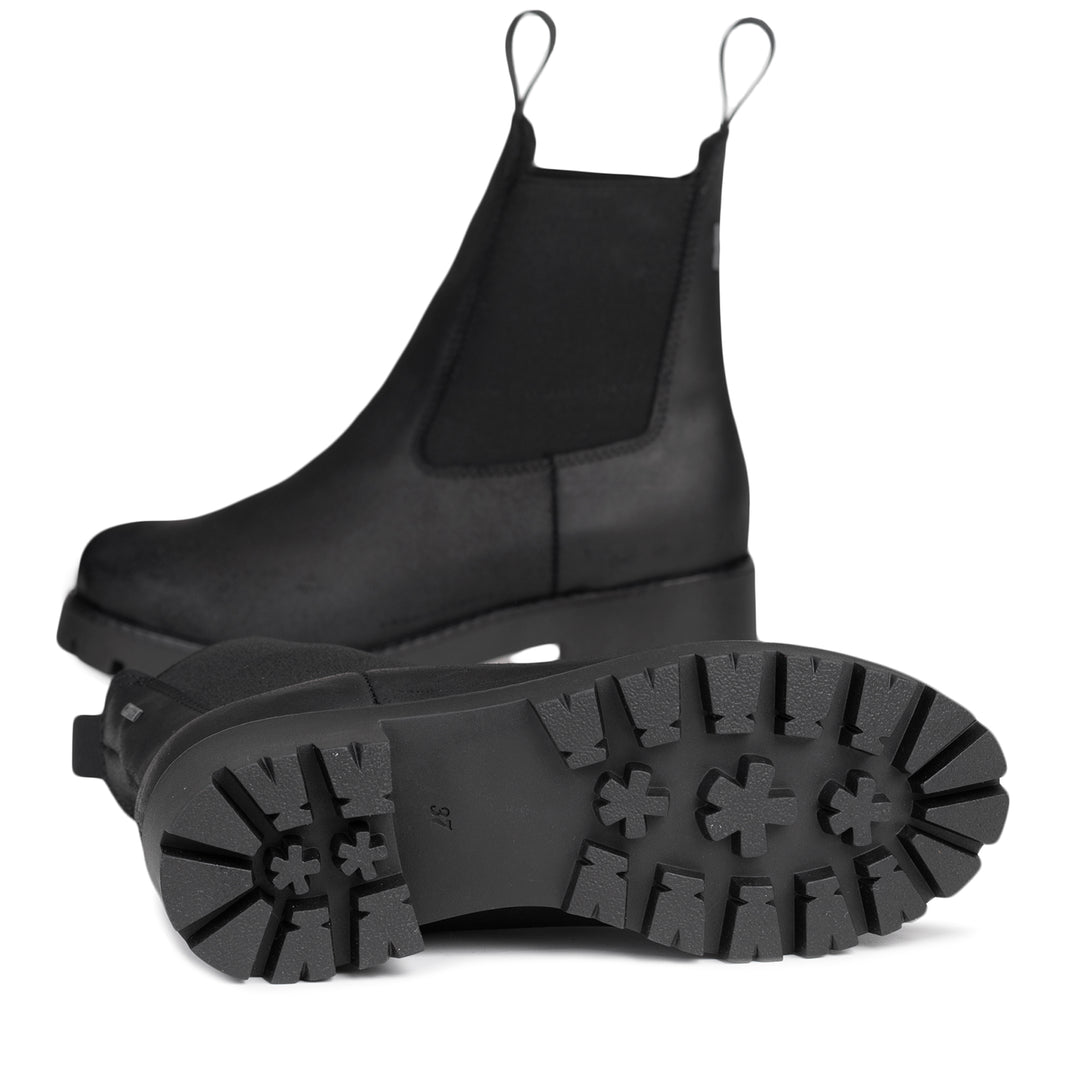 Mustien chelsea-nilkkureiden vahvasti kuvioitu pohja.